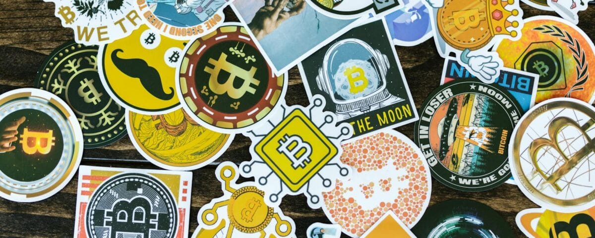 Colorful collection of Bitcoin-themed stickers on a wooden background, ideal for cryptocurrency concepts.