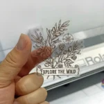 Transparent die cut sticker with a botanical Explore the Wild design