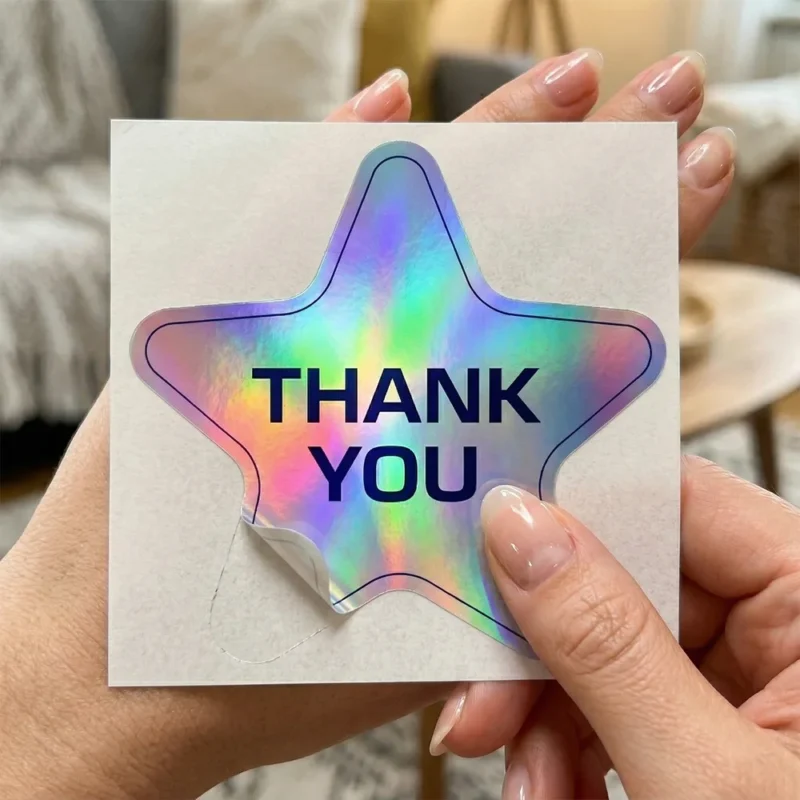 Holographic star Thank You kiss cut sticker on its backing